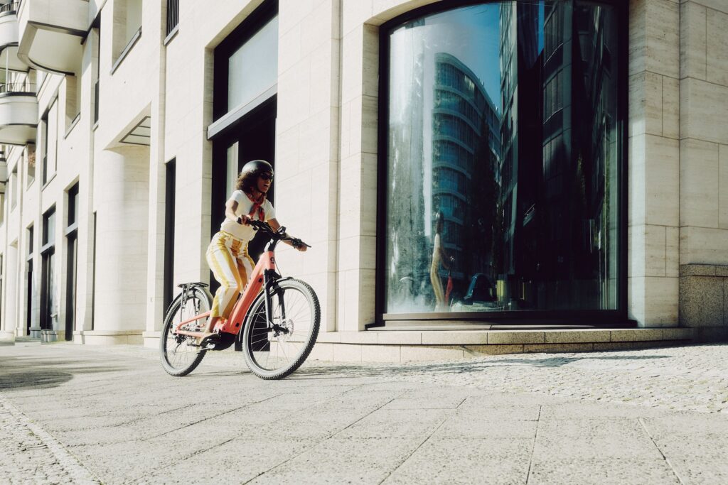 Cycliste sur un Scott E-Ville devant un immeuble, usage vélotaf en ville