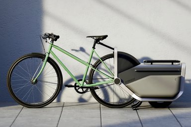 Remorque électrique Convoy C.01 attachée à un vélo, en pleine circulation urbaine