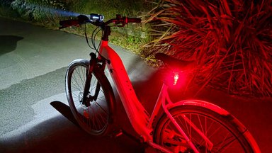 Kit d’éclairage vélo OSRAM LEDsBIKE RACE 50 SET installé sur un vélo, phare avant et feu arrière allumés.