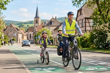 famille circulant à vélo sur une piste cyclable en respectant le code de la route