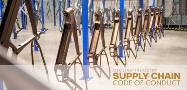 Cadres de vélos suspendus sur une ligne de production industrielle dans une usine de fabrication.