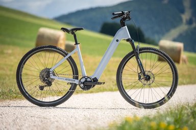 Velo electrique gris a cadre bas eDriven by Ananda sur un chemin de campagne.