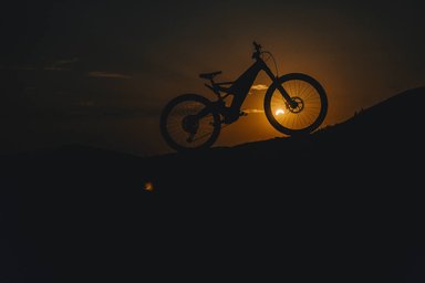 Silhouette du VTT électrique Honda e-MTB Prototype au coucher du soleil