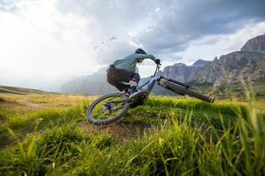 VTT électrique Giant Trance Advanced E+ 2027 en carbone couché en virage sur un sentier de montagne, moteur SyncDrive Pro 4 de 120 Nm