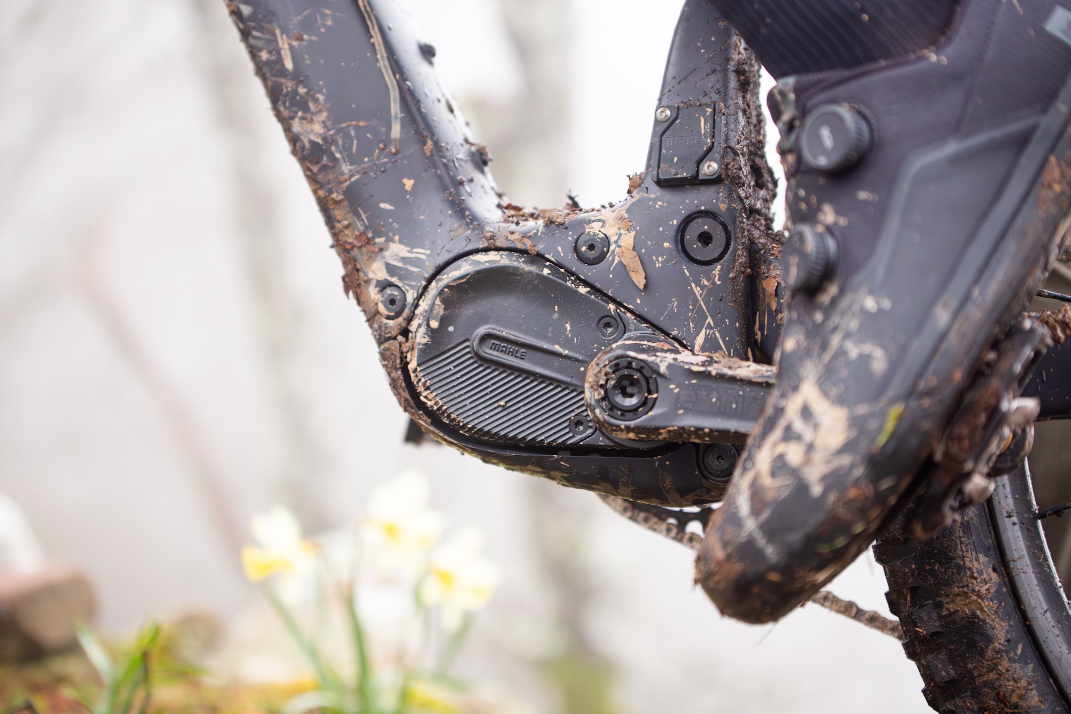 Moteur Mahle M40 monté sur un VTT électrique en pleine action, avec de la boue sur le cadre et un cycliste en train de pédaler