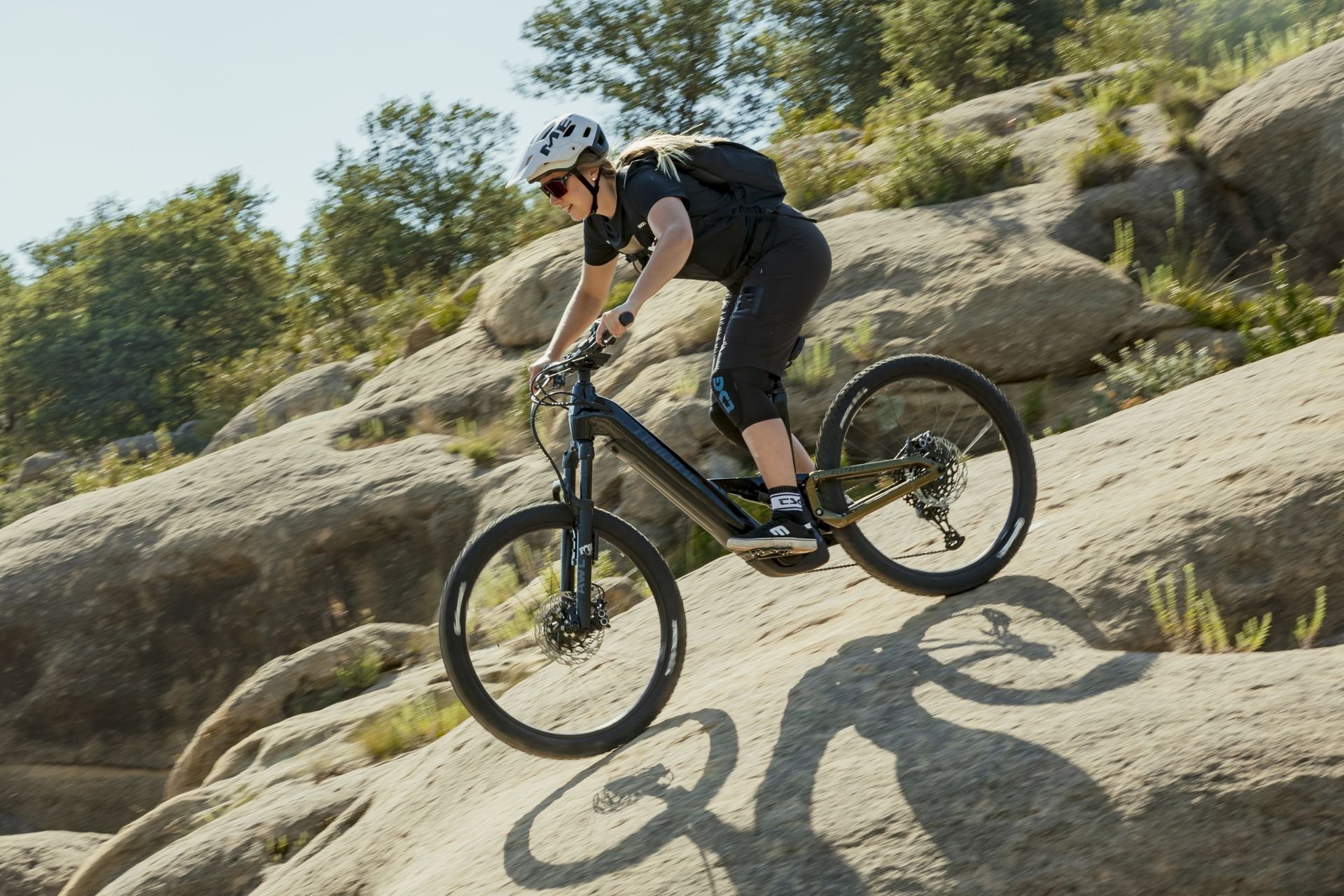 Femme en VTT électrique Haibike Alltrail descendant une piste de montagne rocailleuse