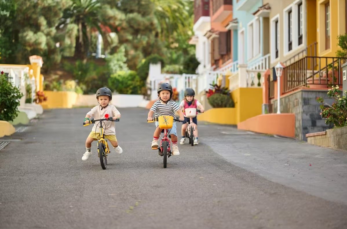 Trois enfants sur des Btwin Discover 500 de 14 pouces, en draisienne et avec pédales