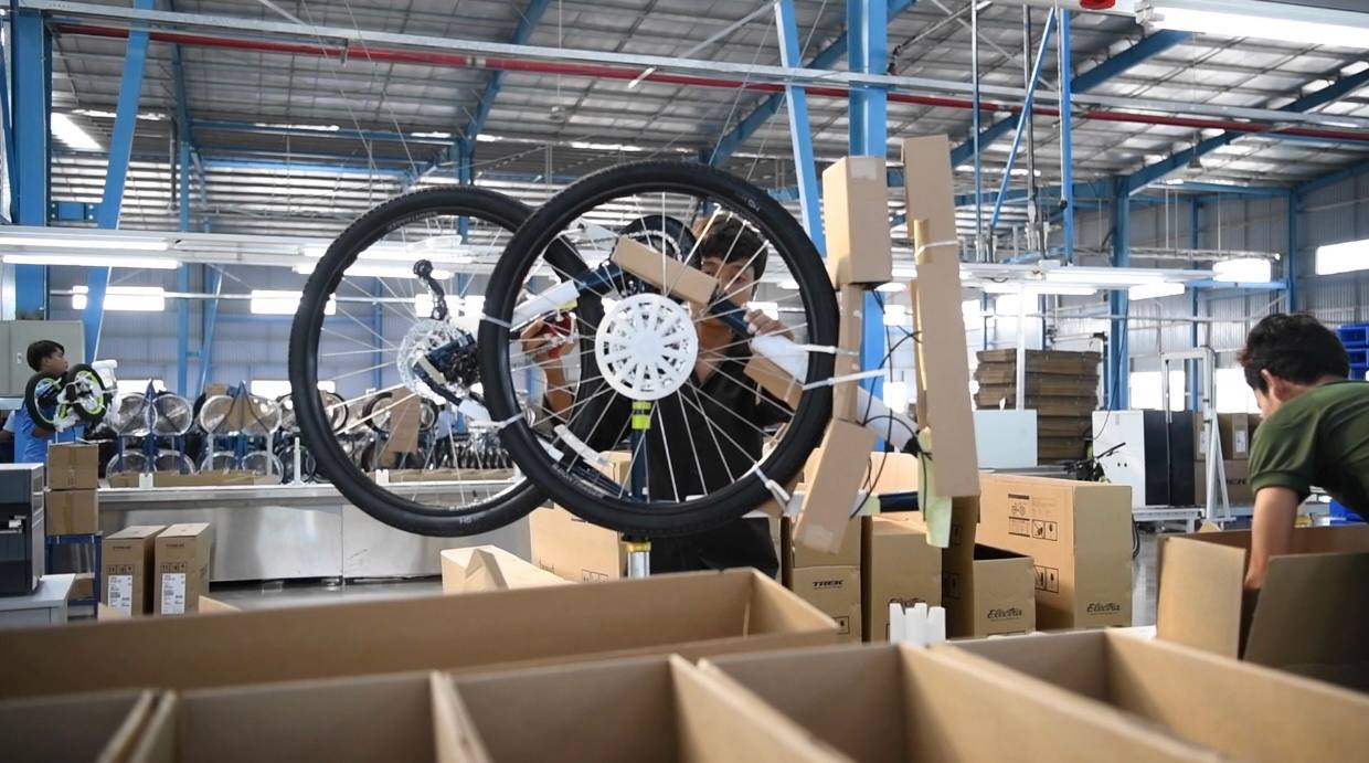 Ouvriers assemblant des vélos Trek et Electra dans une usine au Cambodge pour l'exportation.