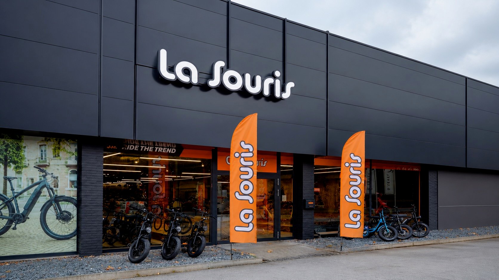 Devanture d'un magasin La Souris avec des fatbikes électriques exposés devant une façade noire moderne.