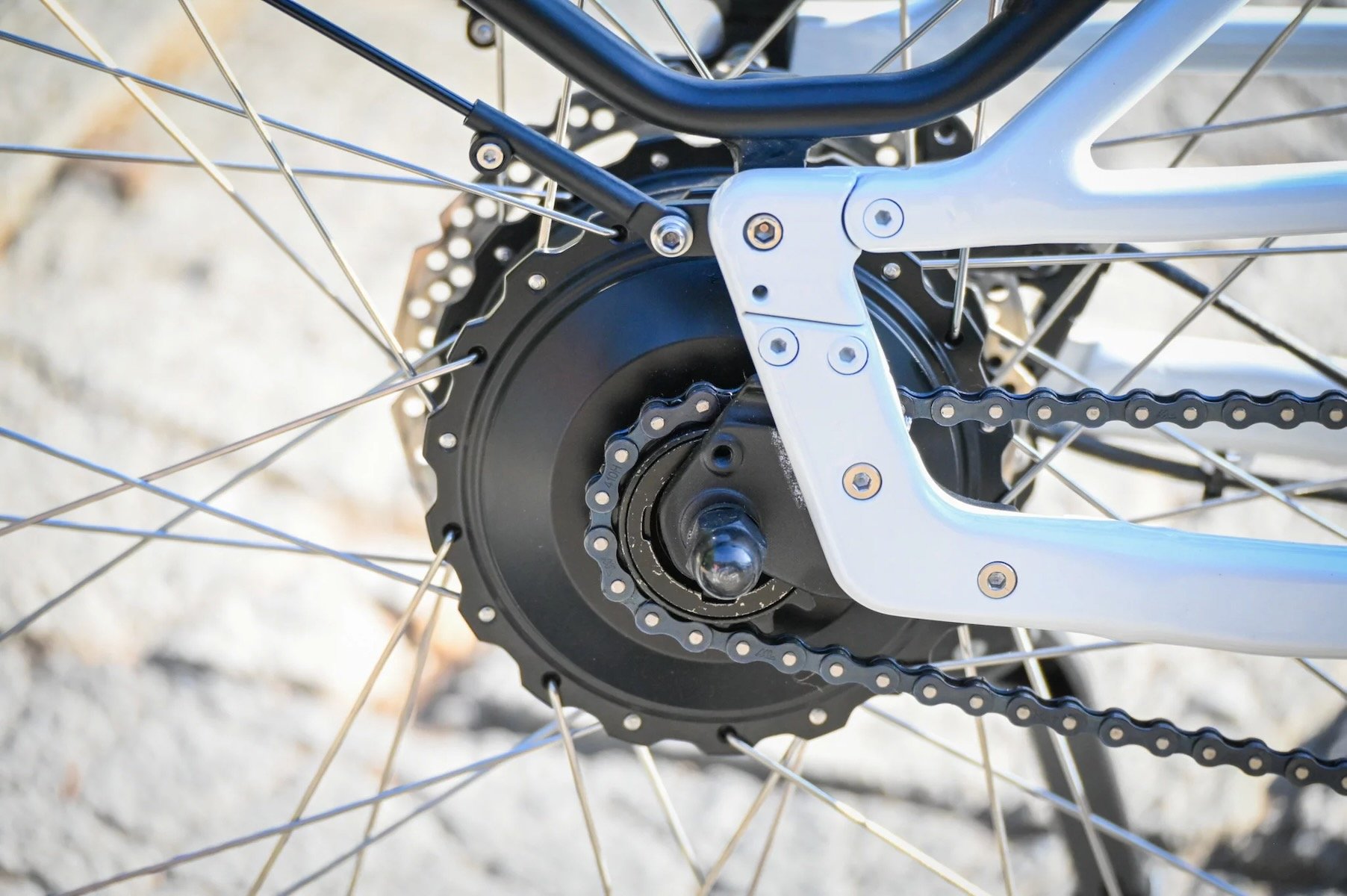 Zoom sur le moteur moyeu arrière d'un vélo électrique avec sa chaîne et son axe de roue.