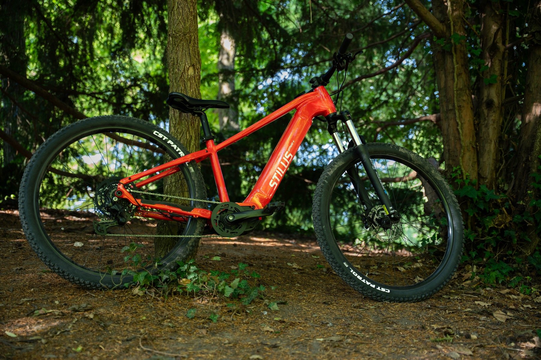 Decathlon Stilus Offroad+ rouge, VTT électrique semi-rigide 29 pouces testé par Cleanrider, vue de profil sur chemin
