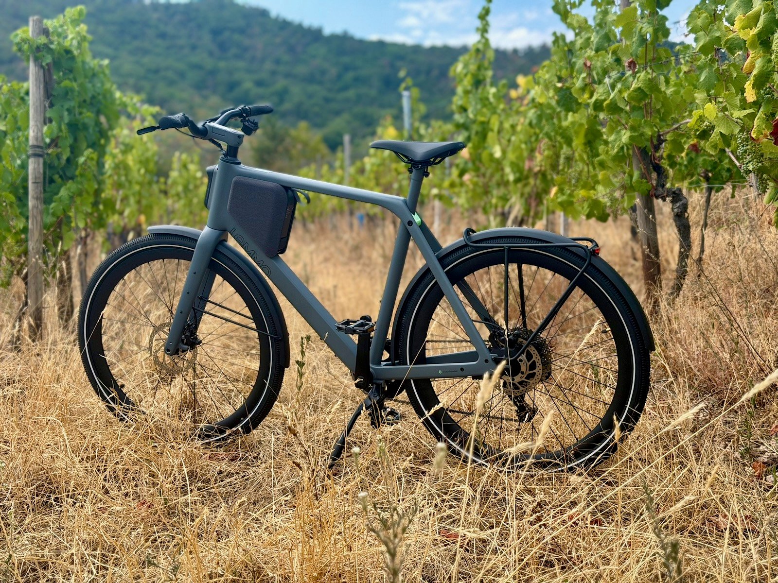 Lemmo One Collab.Ride Core gris de profil dans les vignes, vélo électrique urbain à fourche carbone