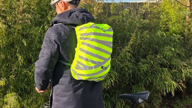 Housse de sac à dos Abus Lumino Urban X-Cover jaune fluo montée sur un sac en usage vélo urbain