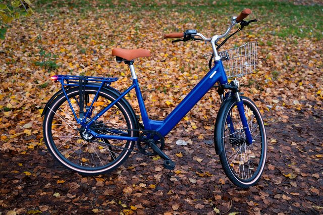 Vélo électrique Brumaire Folio bleu de profil, modèle urbain compact avec courroie Gates et roues de 26 pouces.