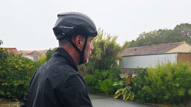 Cycliste portant un bonnet de piscine sous son casque de vélo pour rester au sec sous la pluie