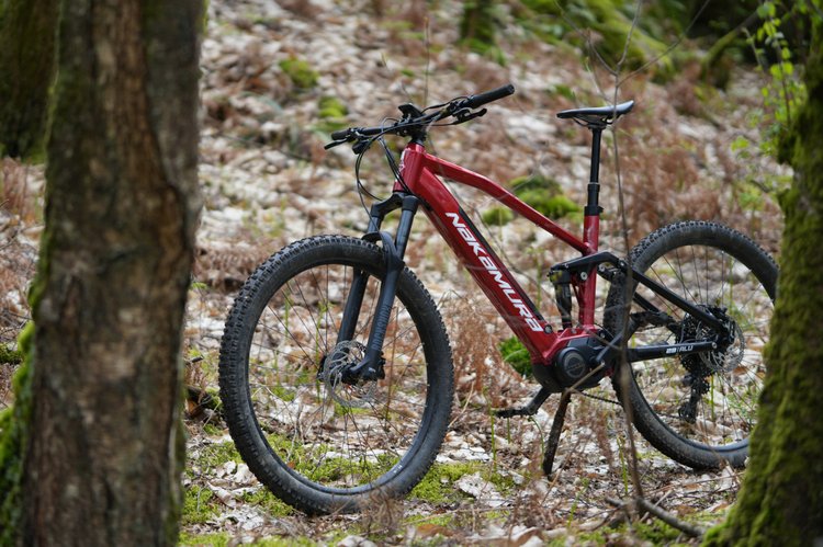 Le VTT électrique tout-suspendu Nakamura E-Summit 950S, un des meilleurs VTTae 2025, photographié en forêt.
