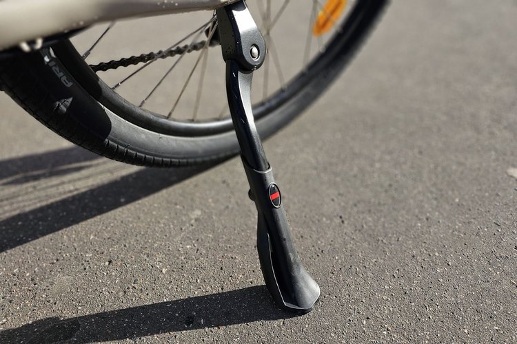 Béquille latérale déployée du vélo électrique Nakamura Crossover E sur l'asphalte