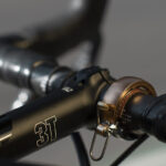 Détail de la sonnette Knog Oi Bell Luxe fixée sur un cintre de vélo