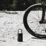 Gonfleur électrique Xiaomi Electric Compressor 2 posé au sol à côté d’un VTT
