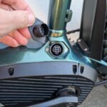 Gros plan sur le port de recharge de la batterie intégrée du VTT électrique Rockrider E-EXPL 700, protégé par un cache.
