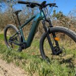 Le VTT électrique Rockrider E-EXPL 700 bleu/vert en test sur un sentier, un des meilleurs VTTae de 2025 pour la randonnée.